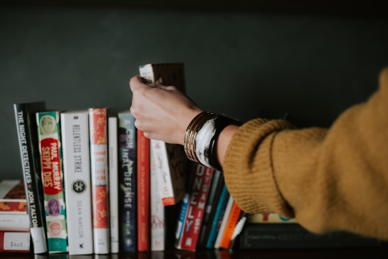 A book wrapped as a gift with ribbon beside a few loose books